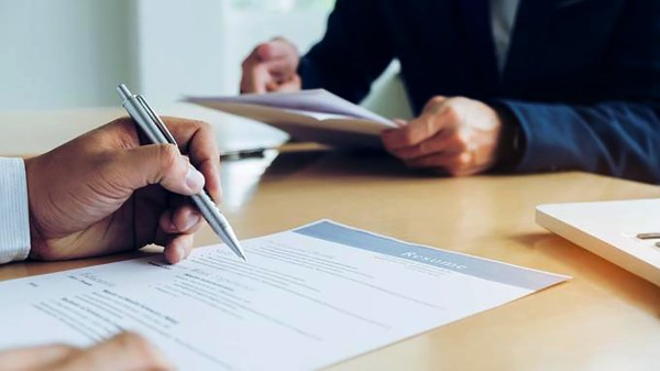 Executive reading a resume during a job interview and businessma